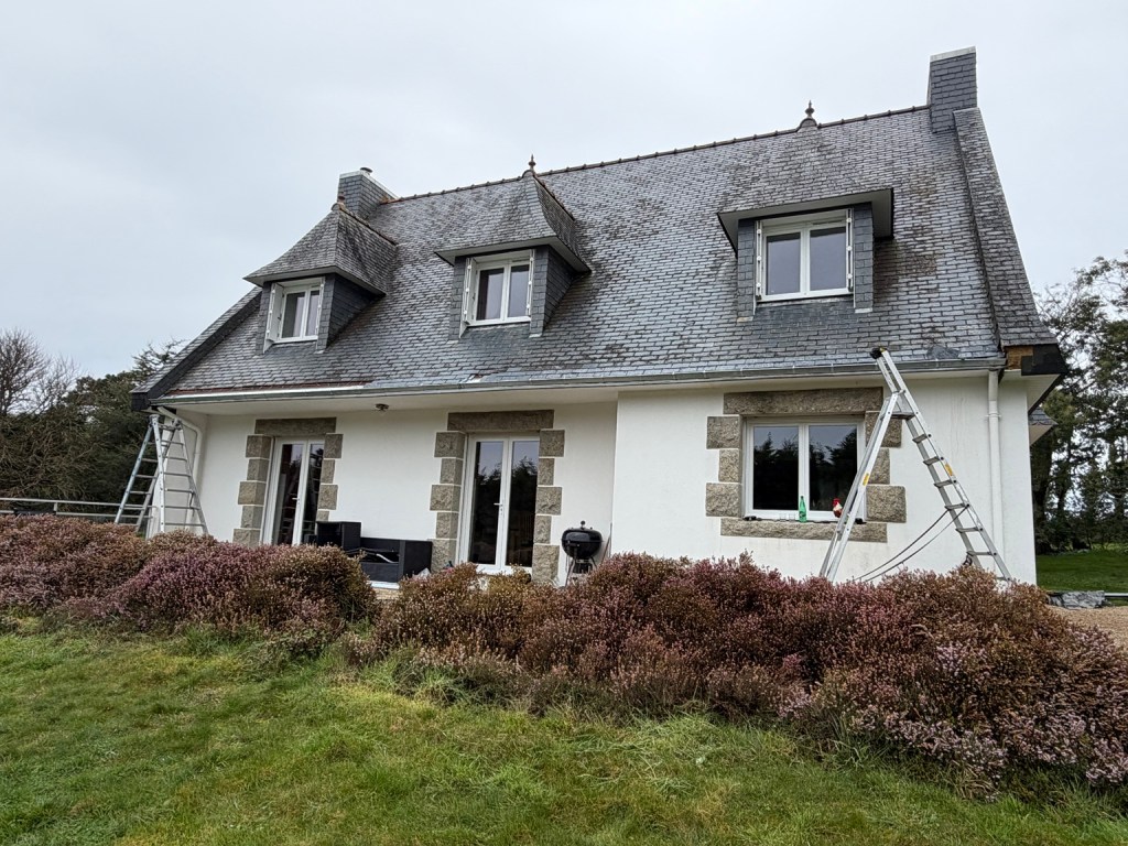 Maison avec toiture en ardoises, gouttière en bas de pente et descente d’eaux pluviales