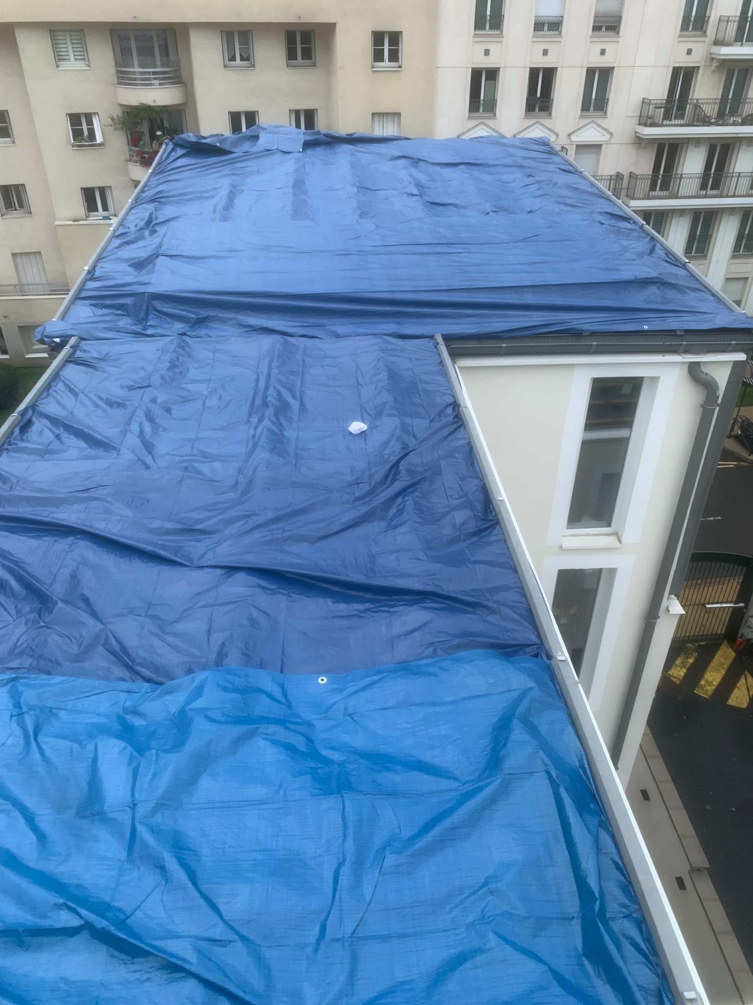 Toiture recouverte d’une bâche bleue, chantier de protection provisoire réalisé par Couvreur Guipavas 29
